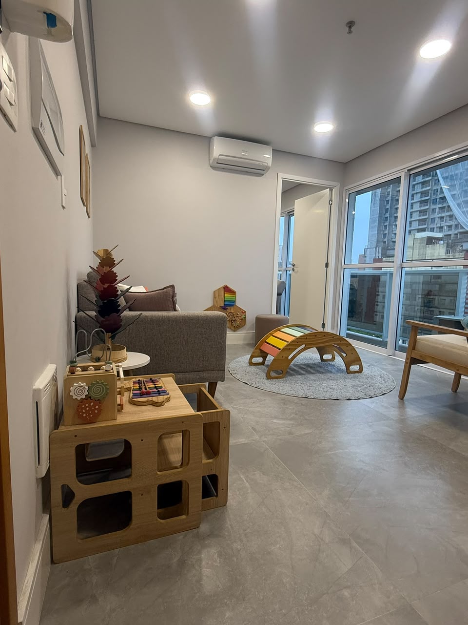 Cantinho de brincar com mesa de atividades, xilofone e sofá para as famílias